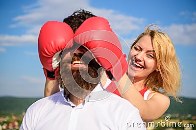 Tricks every woman needs to know. Girl smiling face covers male face with boxing gloves. Cunning tricks to win. Guess Stock Photo