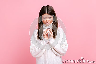 Tricky cunning pretty female standing looks at camera, planning something cunful, pranking somebody. Stock Photo