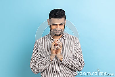 Tricky handsome businessman thinking devious plan with cunning face expression, looking at camera. Stock Photo