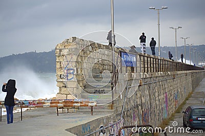Trill seekers looking waves flooding breakwater Editorial Stock Photo