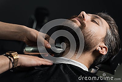 Trimming the beard with a shaving machine. Advertising for barbershop and men& x27;s beauty salon Stock Photo