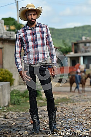 Trinidad, Cuba, August 16th, 2018: Man looking like cowboy walking on the streets of Trinidad Editorial Stock Photo