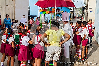 TRINIDAD, CUBA - FEB 8, 2016: Group of Young Pioneer girls and boys at a street food stall in Trinidad, Cub Editorial Stock Photo