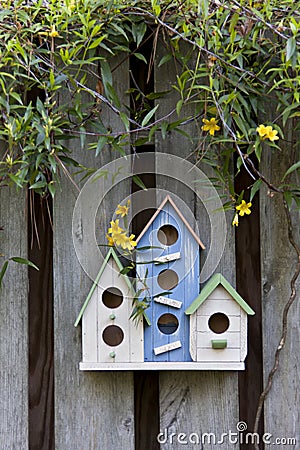 Trio of birdhouses with spring flowers. Stock Photo