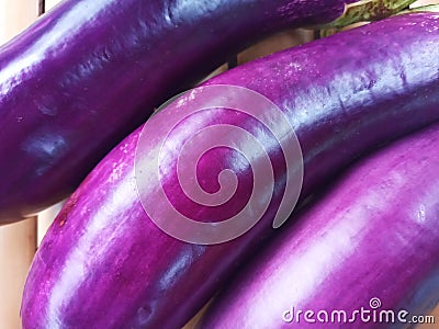 Closeup of Triple Eggplants on Bamboo Surface Stock Photo