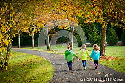 Triplet children walking on a treelined path Stock Photo
