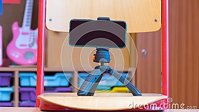 A tripod smartphone used for school online teaching based on a school chair Stock Photo