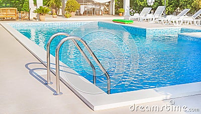 Trogir, Croatia â€“ July 10, 2021: Swimming pool with ladder stainless handrails stairs into the water, chairs for tanning. Editorial Stock Photo