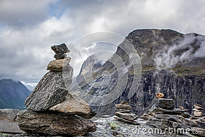 Troll rock pyramid with rainbow on top of Trollstigen road. Stone cairn Stock Photo