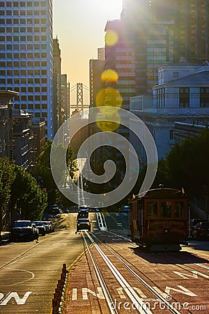 Trolley driving towards Oakland Bay Bridge between skyscrapers in morning light Editorial Stock Photo