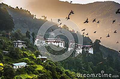 Dawn of Trongsa Dzong , birds wheeling in the air above the castle , Bhutan Stock Photo