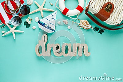 Tropic flat lay with wooden word Dream starfish, shells, sunglasses, boat, earrings on green background. Summer fashion flat lay Stock Photo