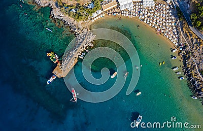 Tropical beach with colorful umbrellas - Top down aerial view. Lindos , Rhodes, Greece. Stock Photo