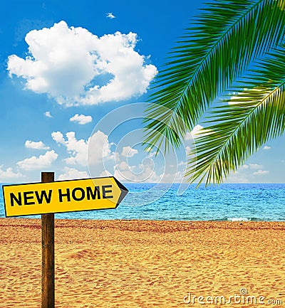 Tropical beach and direction board saying NEW HOME Stock Photo