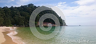 Tropical beach, green hill and green water of the ocean Stock Photo