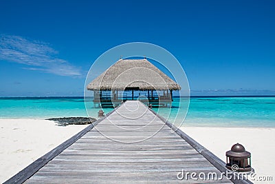 Tropical beach landscape with wooden bridge and house on the water at Maldive Stock Photo