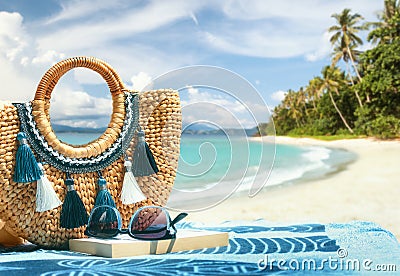 Tropical beach summer holiday accessories, with blurred beach palm trees and sea in background. Stock Photo