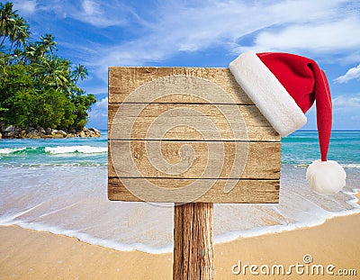 Tropical beach wooden signboard with Christmas hat Stock Photo