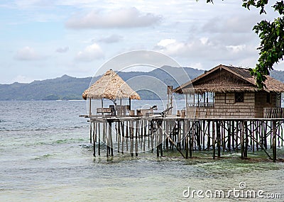 Tropical bungalows with thatched roof on high stilts Stock Photo