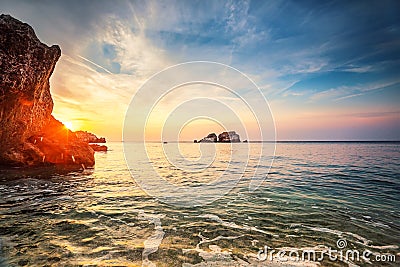 Tropical colorful sunset at the stones beach. Stock Photo