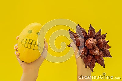 Tropical fruits mango and salak. Smooth mango scared spiny salak. Tropical fruit allergy, fear of unknown fruits Stock Photo