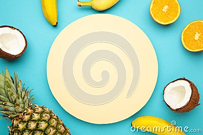 Tropical fruits. Pineapple, coconut, orange and banana on blue background. Space for text Stock Photo