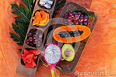 Healthy tropical fruits on wooden plate. Stock Photo