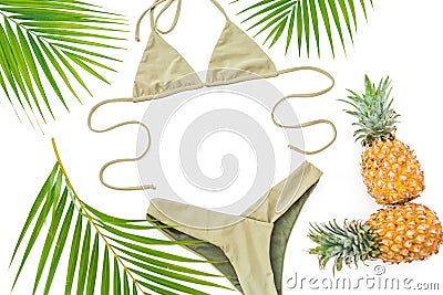 Tropical holiday concept with pineapple, palm leaves and bikini swimwear on white background. Flat lay Stock Photo