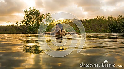 Tropical holidays lifestyle portrait of young beautiful and happy Asian Korean woman in bikini enjoying sunset at amazing jungle Stock Photo