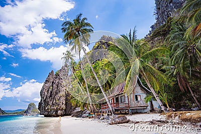 Tropical hut under palm trees on Ipil Beach at Pinagbuyutan Island. El Nido, Palawan, Philippines Stock Photo