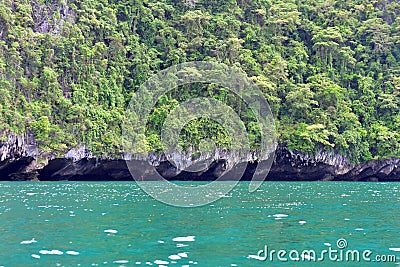 Tropical island with overhang cliff Stock Photo