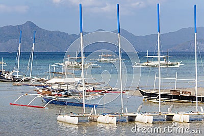 Tropical landscape with traditional Pilippines boats. Palawan island lagoon with mountains on horizon. Stock Photo