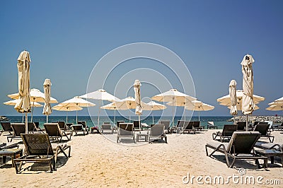 Tropical Paradise. Beach with sun loungers and parasols in Dubai, on the Persian Gulf. The Emirate of RAS al Khaimah. Tinted Stock Photo