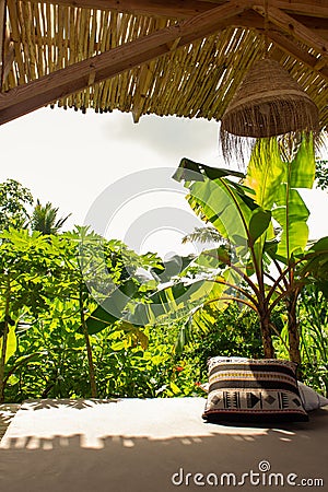 Tropical resort with lounge place with pillows. Holiday villa with garden and comfortable patio. Empty exotic resort. Stock Photo