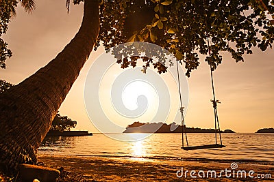 Tropical sea beach with swing tied Stock Photo