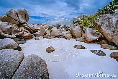 Tropical small secret pristine white sand beach surrounded by granite boulders. Anse Marron beach, La Digue, Seychelles Stock Photo