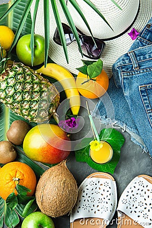 Tropical Summer Fruits Glass of Fresh Juice Pineapple Mango Bananas Coconut on Large Palm Leaf. Women Jeans Shorts Slippers Hat Stock Photo