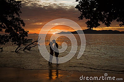 Tropical sunset, ocean shore with silhouette of a lover couple Stock Photo