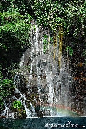 Tropical waterfall detail with rainbow. Stock Photo