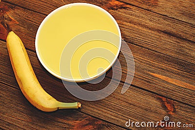 Tropical yellow jelly with banana in a plate on the table. Stock Photo