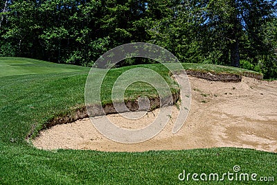 Trouble on the golf course, sand trap protecting a golf green with trees in the background Stock Photo