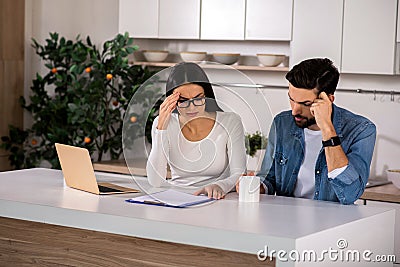 Troubled couple sitting in the kitchen Stock Photo