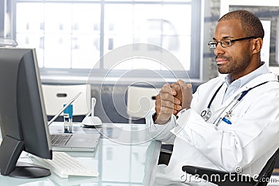 Troubled doctor sitting at desk Stock Photo