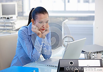 Troubled office girl looking at laptop screen Stock Photo
