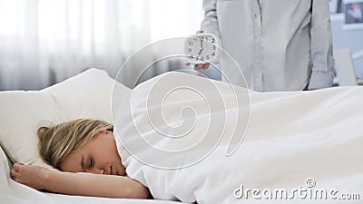 Troubled teenage daughter does not want to wake up in morning, late for school Stock Photo