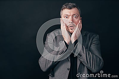 Troubled worried shocked man over black background Stock Photo