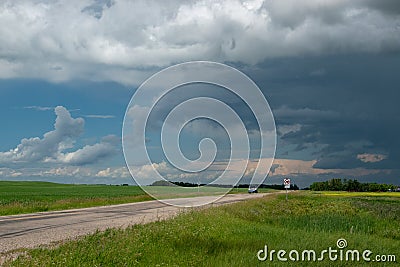 Truck approaching with looming storm clouds, Saskatchewan, Canad Stock Photo
