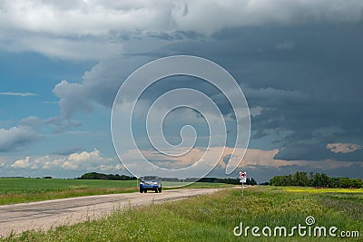 Truck approaching with looming storm clouds, Saskatchewan, Canad Stock Photo