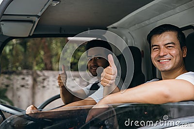 Ethnically diverse mover team driving a truck for relocation service Stock Photo
