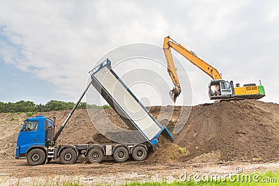 Truck and excavator together build a sound barrier Stock Photo